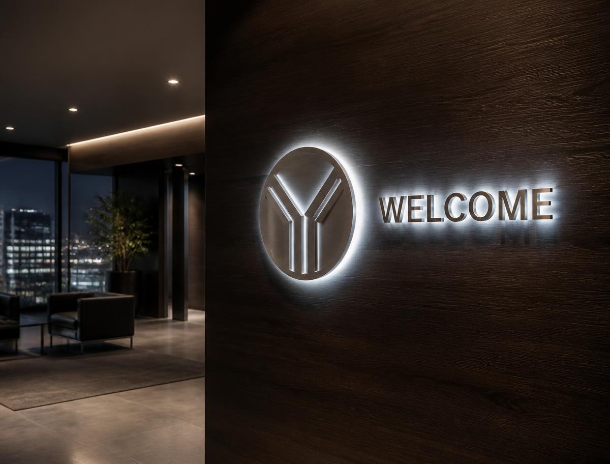Halo-lit circular logo mark and Welcome lettering glowing on a dark walnut lobby wall