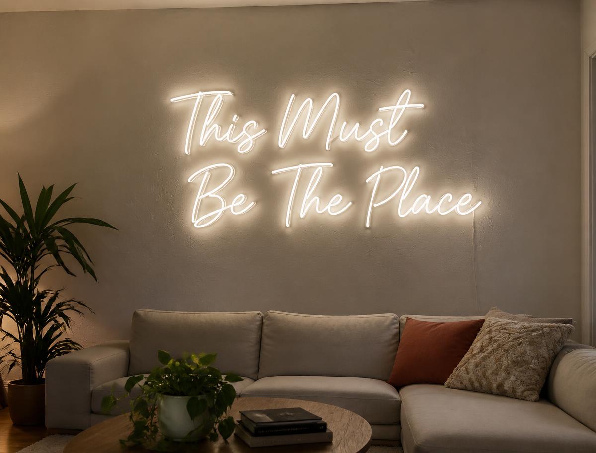 This Must Be The Place LED neon sign on a dark feature wall in a living room